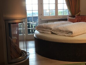 Quarto com cama, aquecedor e janela com cortinas.