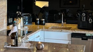 A modern kitchen with granite countertops, stainless steel appliances, and a built-in dishwasher.