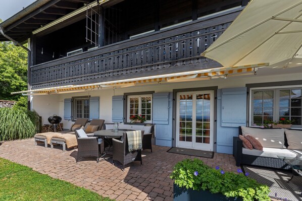 A house with a balcony, outdoor furniture, and a covered patio area.