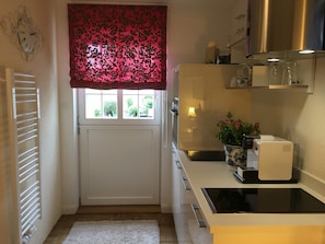A compact kitchen with a window, a radiator, a white countertop, and a small sink. - Apartment 'Mini Suite' with Mountain View, Private Terrace and Wi-Fi (Höchenschwand)