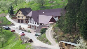 Una casa rural con techo inclinado, un camino de entrada y una carretera que serpentea a su alrededor.