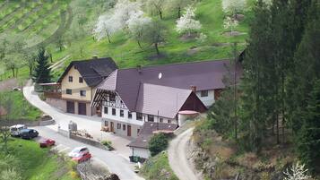 Ein ländliches Haus mit einem geneigten Dach, einer Auffahrt und einer sich schlängelnden Straße.
