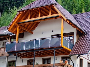 Ein zweistöckiges Gebäude mit Balkon, Holzbalken und einem Ziegeldach.