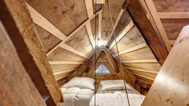 A small attic bedroom with a sloped ceiling, wooden beams, and two beds with white bedding. - Sägerhäusle Holiday Home – Rustic Black Forest Cabin at Feldberg (Feldberg)