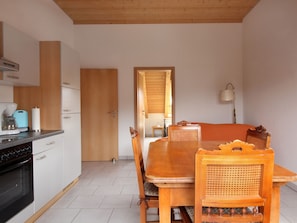 Une cuisine équipée d’une cuisinière, d’une machine à café et d’une table à manger avec des chaises.