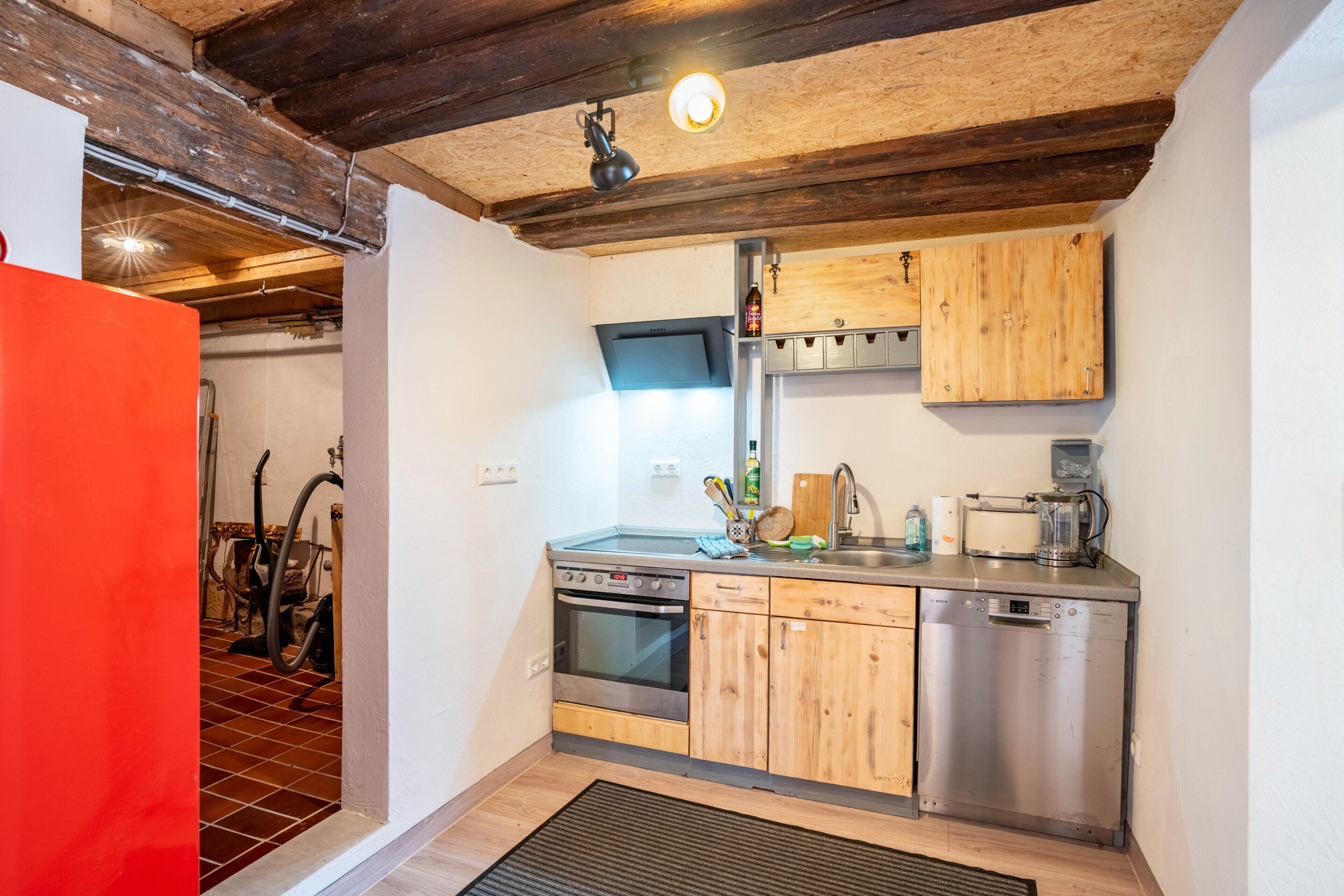 Una cocina con armarios de madera, lavavajillas de acero inoxidable y horno empotrado.