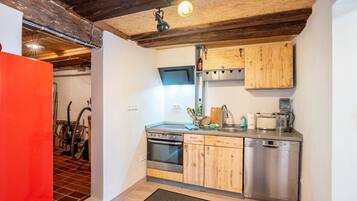 Una cocina con armarios de madera, lavavajillas de acero inoxidable y horno empotrado.