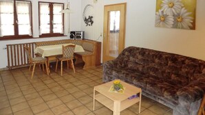 Un salon avec un canapé marron, une table en bois et un banc.
