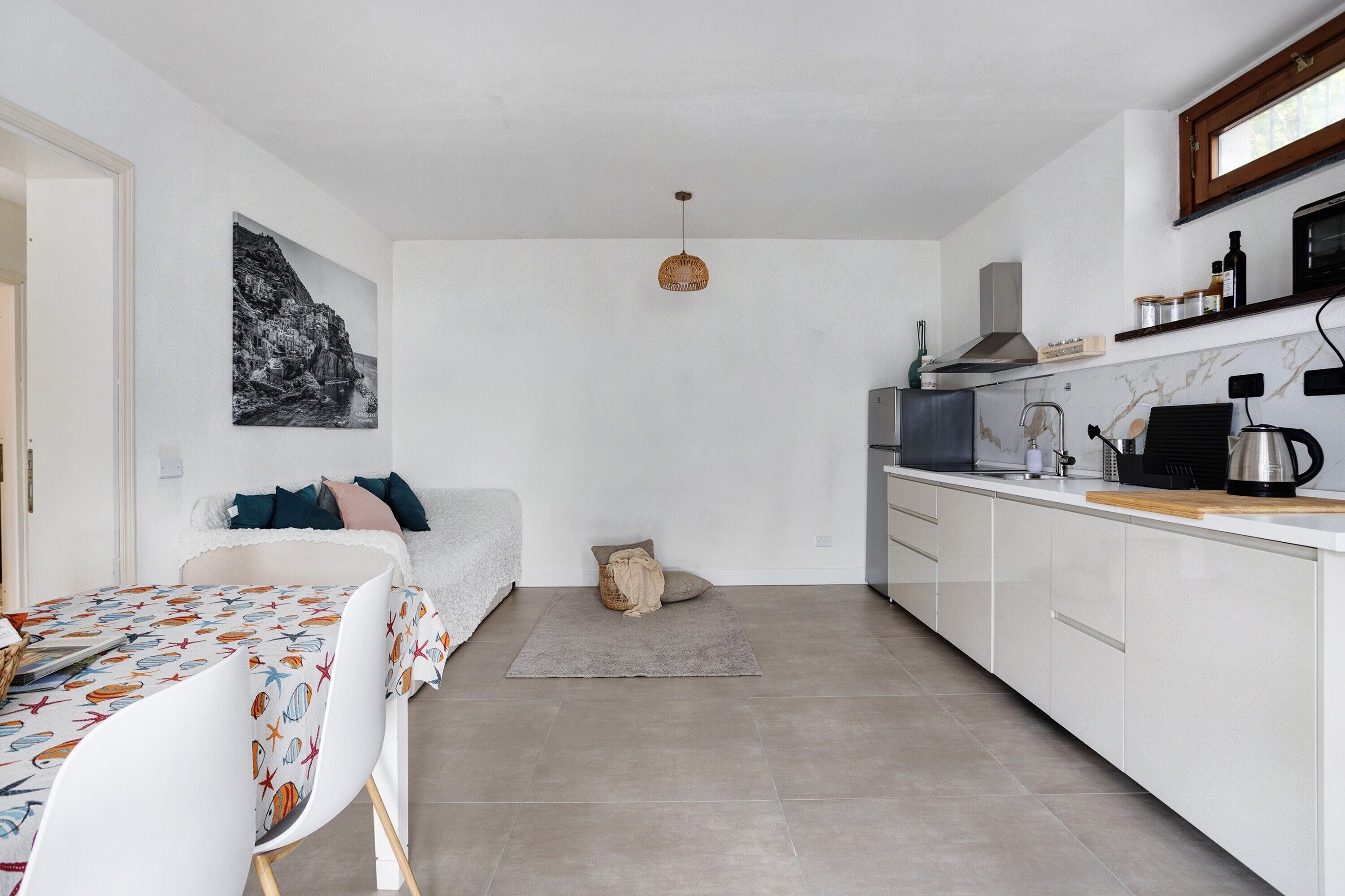 A compact kitchen with white cabinets, a microwave, and a coffee maker.