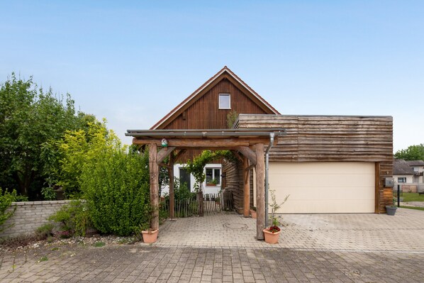 Une grange en bois dotée d’une entrée abritée et d’un garage.
