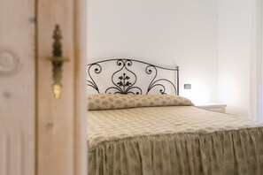 Een bed met een beddegoed met een patroon en een hoofdbord met een decoratief ontwerp.