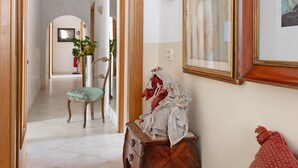 A hallway with a wooden bench, a statue, and a framed picture on the wall. - Room 'Camera 48' with Wi-Fi and Air Conditioning (Verona)