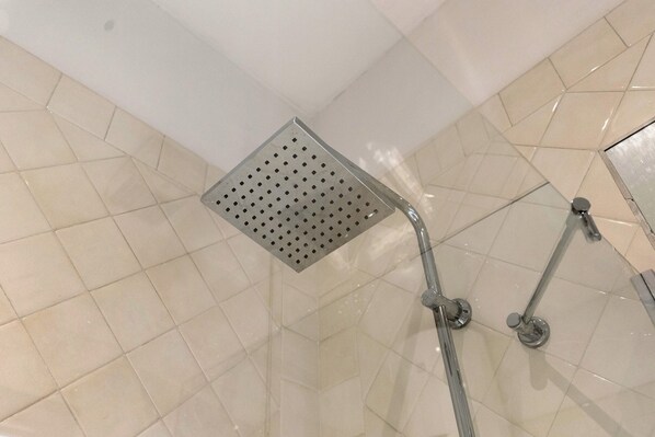 Ducha con cabezal cuadrado y perforado y accesorios de cromo.