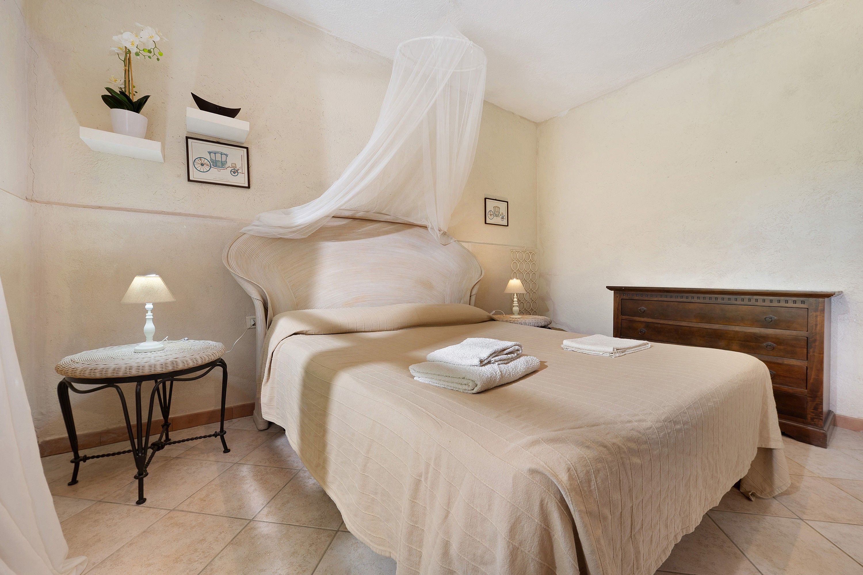 A bedroom with a bed, bedside tables, a nightstand, a dresser, and a canopy bed.