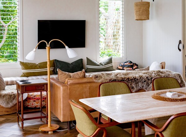 Un salon confortable avec un canapé, une table basse et un téléviseur fixé au mur.