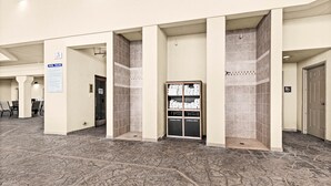 Eine Hotelhalle mit Schwimmbeckenbereich, einer Pinnwand und einem Handtuchhalter.