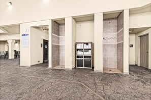 Un hall d’hôtel avec un espace piscine, un tableau d’affichage et un porte-serviettes.