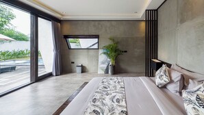 A modern bedroom with a large bed, a potted plant, and a view of the outdoors. - Iri Villas Ubud  (Kemenuh)
