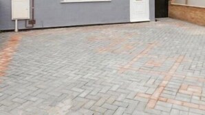 A paved courtyard with a brick pattern, a white door, and a grey wall with a window. - 3 Bedroom House- Loughborough-Sleeps 5-FreeParking (Loughborough)