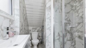 A bathroom with a marble floor, a white sink, a toilet, and a glass shower enclosure. - 3 Bedroom House- Loughborough-Sleeps 5-FreeParking (Loughborough)