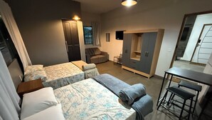 A modern hotel room with two single beds, a sofa, a small table, and a wardrobe. - Casa Paraense  (Manaus)