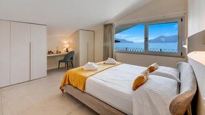 Habitación de hotel con cama, escritorio, silla y vista al mar.