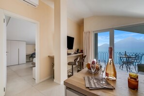Una habitación de hotel con balcón, comedor y vista al mar.