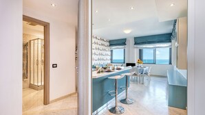 Een moderne keuken met een bar, een eethoek en uitzicht op zee.
