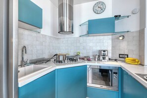 A modern kitchen with a stainless steel range hood, a microwave, and a sink. - Front Beach Magic Sea - Sea Front, Laigueglia, Italy (Laigueglia)