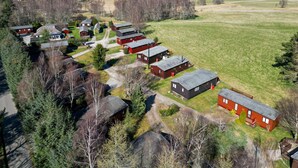 An aerial view of a residential area with multiple houses, a central road, and surrounding fields. - Lodge 3 by Interhome (Boat of Garten)
