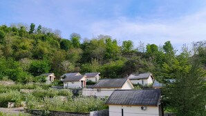 A residential area with houses on a hillside, surrounded by dense greenery. - Lombokhouse Mandalika (Kuta)