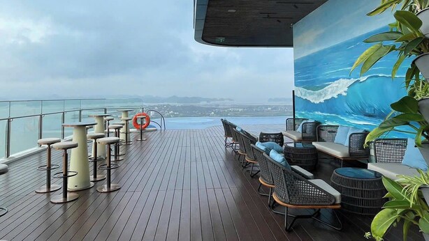 Terraza con asientos al aire libre, un flotador salvavidas y un mural del océano.