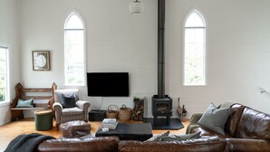 Amplia sala de estar con chimenea, televisor y asientos cómodos.