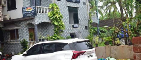 A white SUV parked in front of a building with a sign reading 'Crystal Bay Baga.'