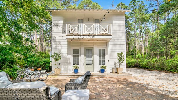 A two-story house with a balcony, potted plants, and outdoor seating. - "Idlehour" new cottage in Fairhope, AL - NEW LISTING (Fairhope)