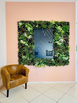 Relax in a serene space with a lush vertical garden and a cozy leather armchair.
