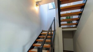 Eine moderne Treppe mit Holzbodenstufen und Metallgeländern, die zu einer oberen Etage führt.