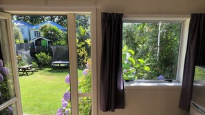 Una habitación con puerta corrediza de vidrio que da a un jardín.