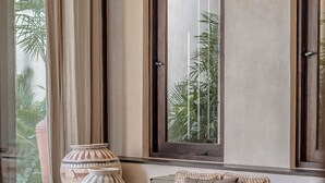 A cozy seating area with a sofa, a coffee table with books and decorative items, and a large vase.