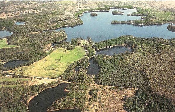 An aerial view of a natural landscape with multiple water bodies and dense forest areas.