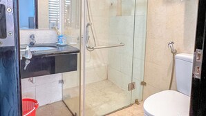 A modern bathroom with a glass-enclosed shower, a white toilet, and a sink with a mirror. - Ann Apartment (Hai Phong)