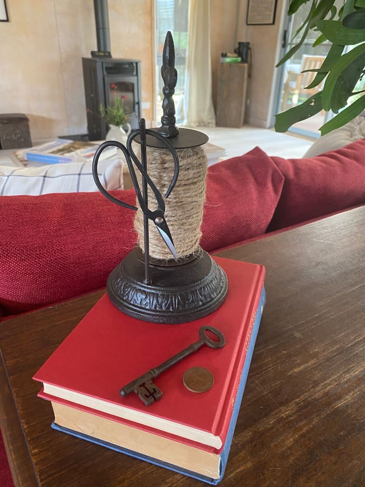 A book with a key and a coin on top, placed on a wooden table.