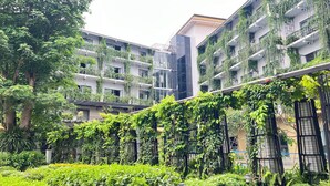 Un edificio a più piani con ampie pareti verdi e vegetazione.