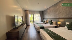 A hotel room with two beds, a TV, a desk, and a balcony with curtains. - X Hotel Thai Nguyen (Phan Dinh Phung)