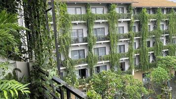 Een meerlaags gebouw met balkons overwoekerd door weelderige groene klimop.