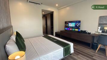 A hotel room with a bed, a desk, a television, and a mirror.