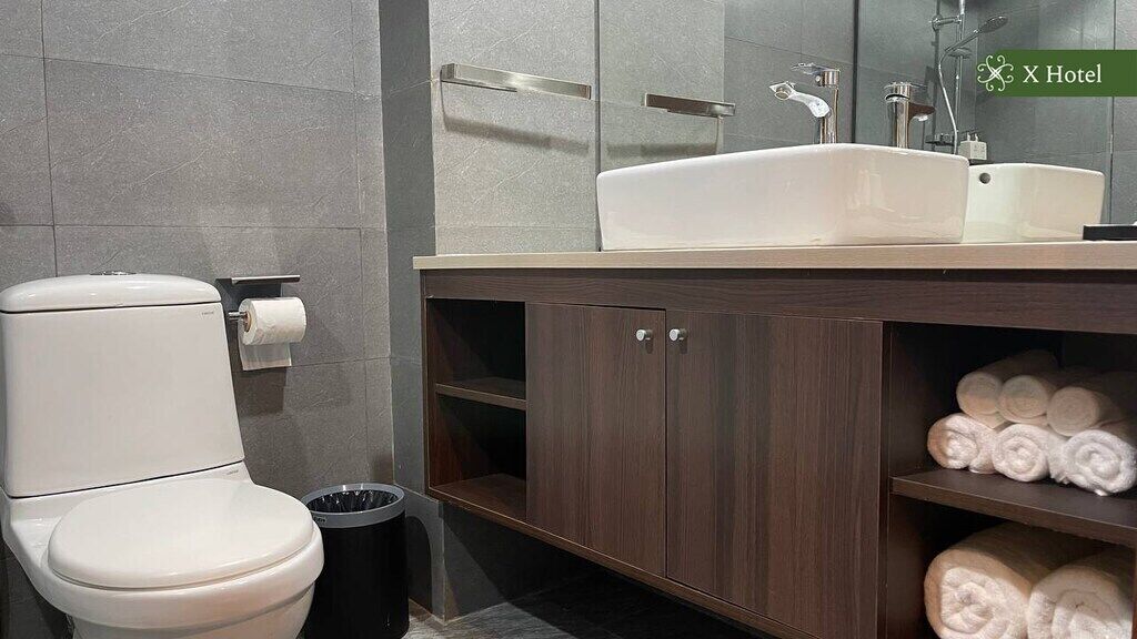 A modern bathroom with a toilet, sink, and towel rack.