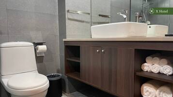 A modern bathroom with a toilet, sink, and towel rack.