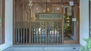Ein hölzernes Tor mit einem Schild, auf dem 'Mimoya STAY' steht.
