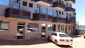 A multi-story building with a modern design, featuring balconies on each floor and a brick facade. - Helsinki Hotel Nyamira (Nyamira)